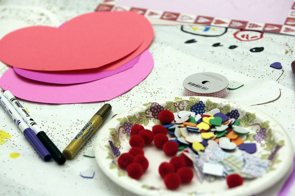 valentine diy decor ideas featuring handmade paper hearts and mason jar candle holders on a rustic wooden table